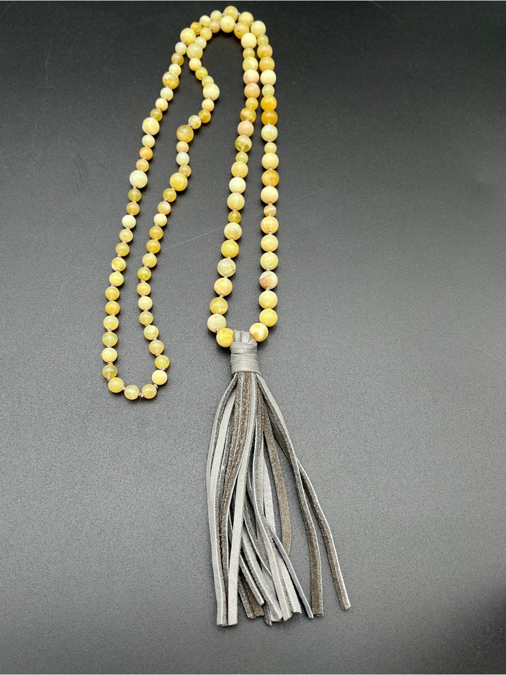 Golden Opals hand knotted with soft grey leather tassels